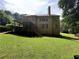 Back view of home with covered patio and spacious backyard surrounded by trees at 403 Glenhurst Trce, Canton, GA 30115