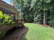 Lush green backyard with mature trees and a wooden deck, perfect for relaxation at 403 Glenhurst Trce, Canton, GA 30115