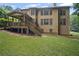 Exterior view of the home with a screened porch and deck overlooking a large grassy backyard surrounded by trees at 403 Glenhurst Trce, Canton, GA 30115