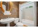 Traditional bathroom featuring a pedestal sink, toilet, and tub with shower, accented by a gold-framed mirror at 403 Glenhurst Trce, Canton, GA 30115