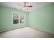 Bright bedroom featuring light green walls, plush carpet, and a window with a view of the outdoors at 403 Glenhurst Trce, Canton, GA 30115