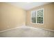 A quiet bedroom with neutral walls, carpet, and a bright window at 403 Glenhurst Trce, Canton, GA 30115