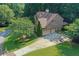 An exterior view of a brick two-story home with mature trees and a long driveway leading to a two-car garage at 403 Glenhurst Trce, Canton, GA 30115