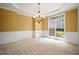 A carpeted room showcasing wainscoting and a window with natural light at 403 Glenhurst Trce, Canton, GA 30115