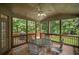 Cozy screened-in porch with ceiling fan, outdoor furniture, and wood flooring, overlooking a lush backyard at 403 Glenhurst Trce, Canton, GA 30115