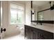 Well-lit bathroom featuring a dark vanity, a window, and neutral colored walls at 4975 Rebel Trl, Atlanta, GA 30327