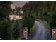 Long driveway leading to the home at twilight with stone gateposts and landscape lighting at 4975 Rebel Trl, Atlanta, GA 30327