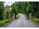 Long driveway leading to the home with stone gateposts and manicured landscaping at 4975 Rebel Trl, Atlanta, GA 30327