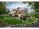 Lush landscaping surrounding home with stone exterior, red tile roof, and view of the pool at 4975 Rebel Trl, Atlanta, GA 30327