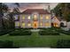 Elegant stone home with lush front yard and fountain, viewed at dusk at 4975 Rebel Trl, Atlanta, GA 30327
