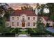 Elegant stone home featuring a formal garden with fountain, arched entryway, and picturesque surroundings at dusk at 4975 Rebel Trl, Atlanta, GA 30327
