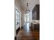 Hallway featuring hardwood floors, glass door, dark wood cabinets, and modern chandelier at 4975 Rebel Trl, Atlanta, GA 30327