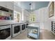 Well-lit laundry room featuring four washing machines, marble counters, island and ample storage at 4975 Rebel Trl, Atlanta, GA 30327