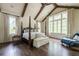 Bright main bedroom featuring vaulted ceiling, exposed beams, hardwood floors, and large windows at 4975 Rebel Trl, Atlanta, GA 30327