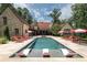 Luxury home featuring a large pool with in-pool loungers, surrounded by lounge chairs and mature landscaping at 4975 Rebel Trl, Atlanta, GA 30327