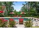 Pool with red and white umbrellas and chairs providing a private oasis surrounded by mature landscaping at 4975 Rebel Trl, Atlanta, GA 30327