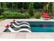 Relaxing in-pool loungers with red pillows, situated in a beautiful outdoor area surrounded by garden at 4975 Rebel Trl, Atlanta, GA 30327