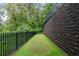 Private putting green alongside a retaining wall, enclosed by a black fence and lush landscaping at 4975 Rebel Trl, Atlanta, GA 30327