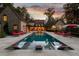 Luxurious outdoor swimming pool with lounge chairs and sun umbrellas at dusk at 4975 Rebel Trl, Atlanta, GA 30327