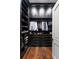 Organized walk-in closet with dark wood shelves, cabinets, drawers, and hardwood floors at 4975 Rebel Trl, Atlanta, GA 30327