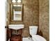 Elegant powder room features patterned wallpaper, pedestal sink, and ornate mirror at 775 Mountain View Nw Ter, Marietta, GA 30064