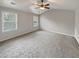 Bright bedroom featuring gray walls, plush carpeting, a ceiling fan, and windows for natural light at 12981 Dartmore Cir, Alpharetta, GA 30005