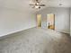 Large main bedroom with gray walls, plush carpet, ceiling fan, and attached bathroom at 12981 Dartmore Cir, Alpharetta, GA 30005