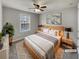 A bedroom featuring a ceiling fan, window and neutral colored bedding at 12981 Dartmore Cir, Alpharetta, GA 30005