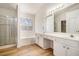Bright bathroom features a double sink vanity, soaking tub, and glass-enclosed shower at 2225 Saint Thomas Way, Suwanee, GA 30024