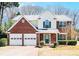 Charming two-story home with a brick front, attached two-car garage and a well-manicured lawn at 2225 Saint Thomas Way, Suwanee, GA 30024