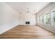 Bright living room featuring wood floors, fireplace, modern lighting, and large windows offering ample natural light at 2225 Saint Thomas Way, Suwanee, GA 30024