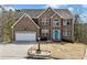 Charming two-story brick home featuring an attached two-car garage and a well-maintained front yard at 4046 Arnolds Mill Opas, Douglasville, GA 30135