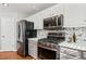 Kitchen boasts modern appliances, gray lower cabinets, and a stylish backsplash at 4046 Arnolds Mill Opas, Douglasville, GA 30135