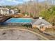 Aerial view of a community pool surrounded by a parking lot and a building at 828 Royal Red Ct, Mcdonough, GA 30253