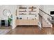 Stylish hallway featuring a decorative cabinet with floating shelves and carpeted stairs at 828 Royal Red Ct, Mcdonough, GA 30253