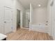Bright bathroom features wood-look flooring, a glass-enclosed shower, and a soaking tub at 903 Hollytree Pl, Acworth, GA 30102