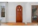 Foyer with arched wooden front door with diamond details, white walls and trim at 1181 Lanier Ne Blvd, Atlanta, GA 30306