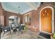 Inviting covered porch with brick columns, seating area, and arched doorway to home at 1181 Lanier Ne Blvd, Atlanta, GA 30306