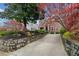 Brick home with a driveway and stone retaining wall, surrounded by lush landscaping at 1181 Lanier Ne Blvd, Atlanta, GA 30306