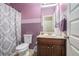 Clean bathroom features lavender accents, patterned shower curtain and vanity with storage at 1695 Stone Meadow Rd, Lithonia, GA 30058