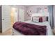 This bedroom features a bed with a purple throw blanket and white trim at 1695 Stone Meadow Rd, Lithonia, GA 30058