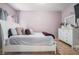 This bedroom features a comfy looking bed, several pillows, and light purple walls at 1695 Stone Meadow Rd, Lithonia, GA 30058