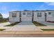 Modern townhome exterior with attached garages, simple landscaping, and a concrete driveway at 216 Sanctuary Dr, Mcdonough, GA 30253