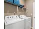 Functional laundry room with modern washer and dryer units, wire rack shelving, and essential hookups at 216 Sanctuary Dr, Mcdonough, GA 30253