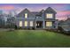 Charming two-story home with a well-manicured lawn and a welcoming front porch at dusk at 430 Parkbrook Way, Canton, GA 30114