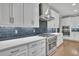 Modern kitchen featuring white cabinets, stainless steel appliances, and stylish backsplash at 430 Parkbrook Way, Canton, GA 30114