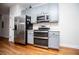 Modern kitchen with stainless steel appliances, gray cabinets, and hardwood flooring at 2657 Neighborhood S Walk, Villa Rica, GA 30180