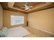 Bright main bedroom featuring a tray ceiling, ceiling fan, and large windows at 2657 Neighborhood S Walk, Villa Rica, GA 30180