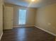 Simple bedroom with hardwood floors, neutral walls, and a window for natural light at 5860 Elm Tree Dr, Buford, GA 30518