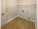 Empty laundry room with tile flooring, wire shelving, and washer/dryer hookups at 6503 Foggy Oak Dr, Fairburn, GA 30213